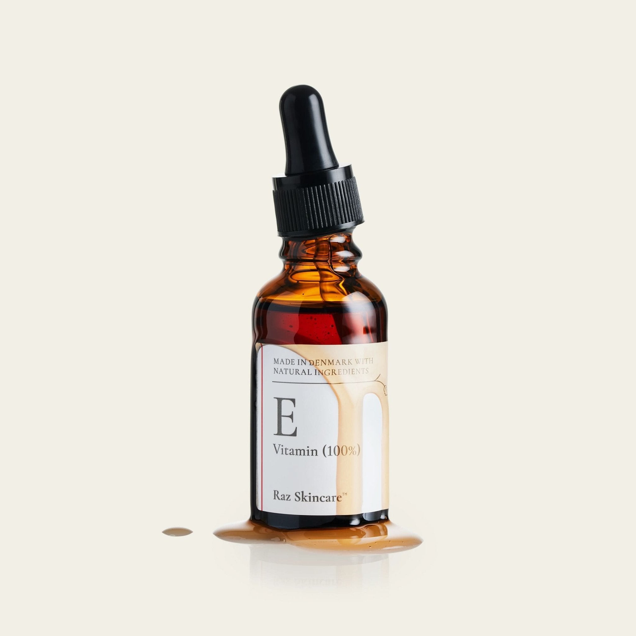 E - Vitamin 100% flyder ud af flasken og flyder ned på et bord